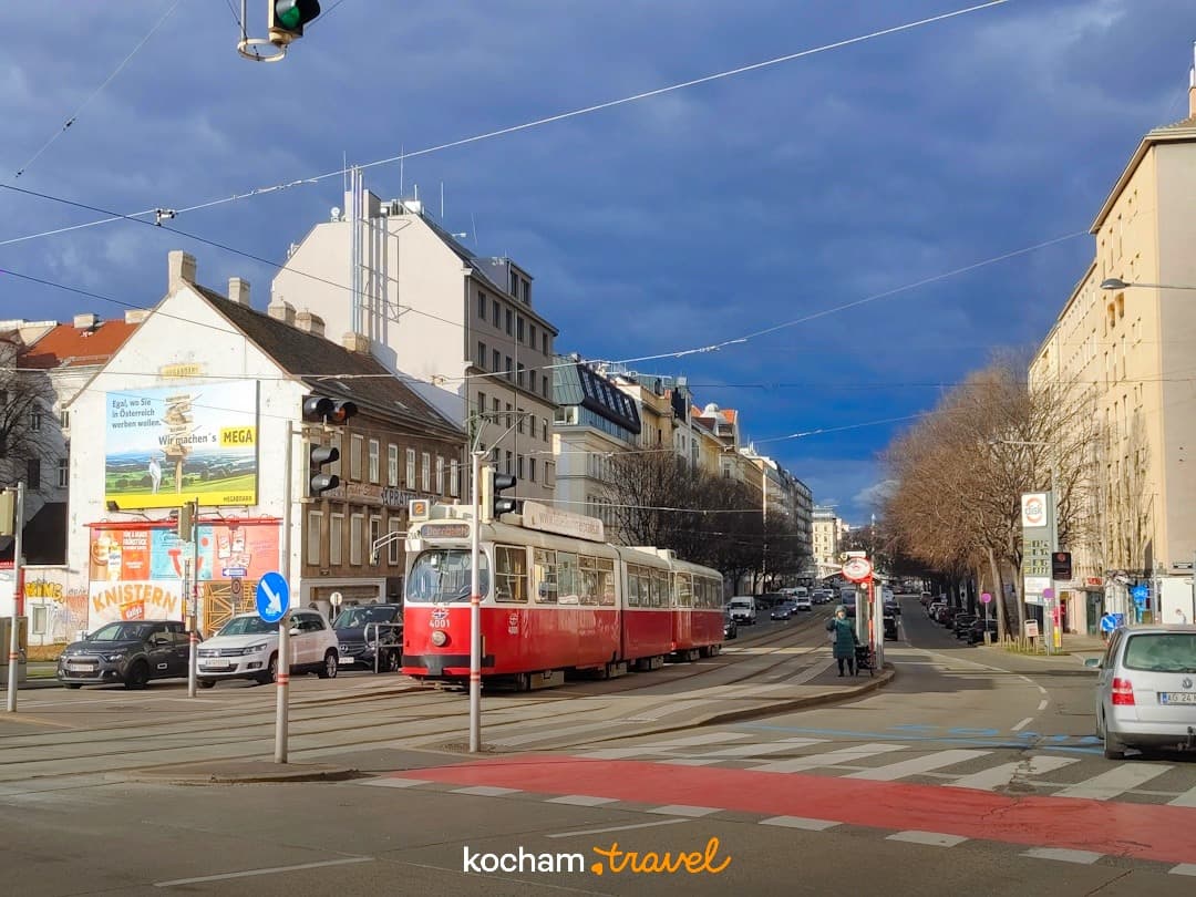 Wiedeński tramwaj na ruchliwej ulicy, budynki, miejski pejzaż, dramatyczne niebo.