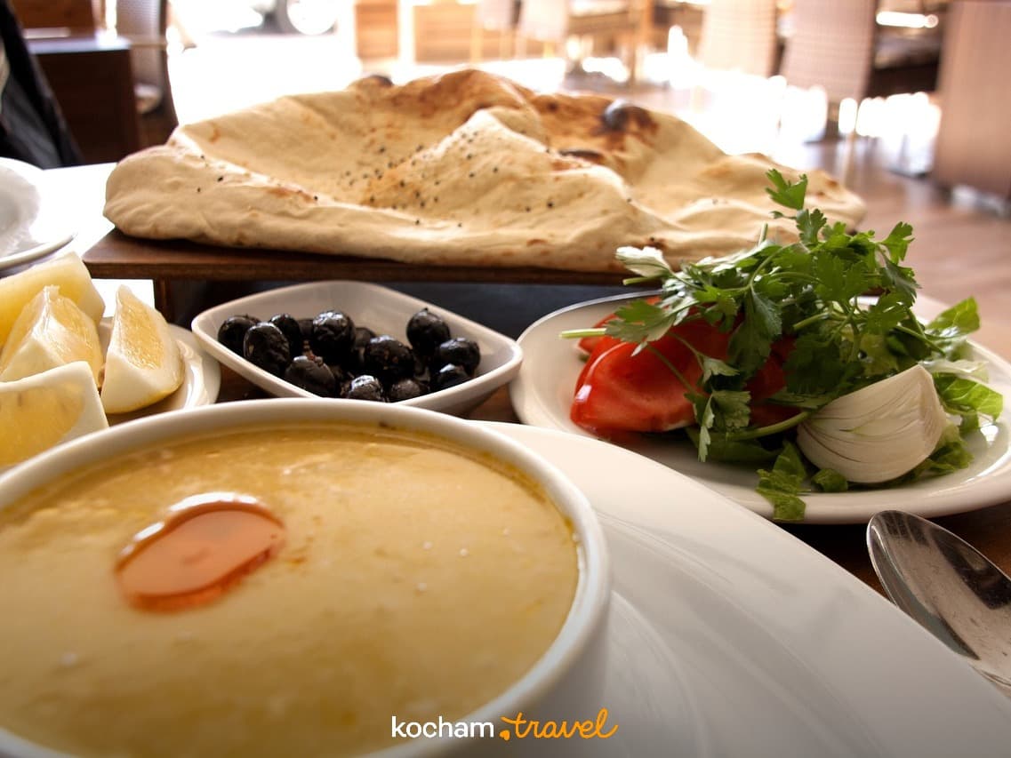 Tradycyjne dania restauracyjne: zupa, chleb, sałatka, oliwki, cytryna.