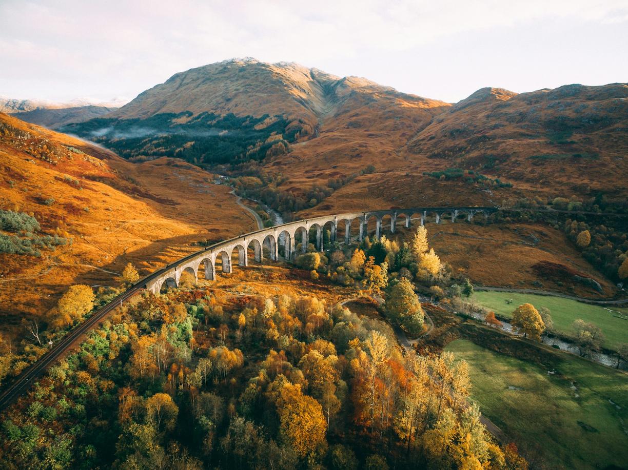 Jesienny krajobraz Szkocji z wiaduktem Glenfinnan i złotymi drzewami.