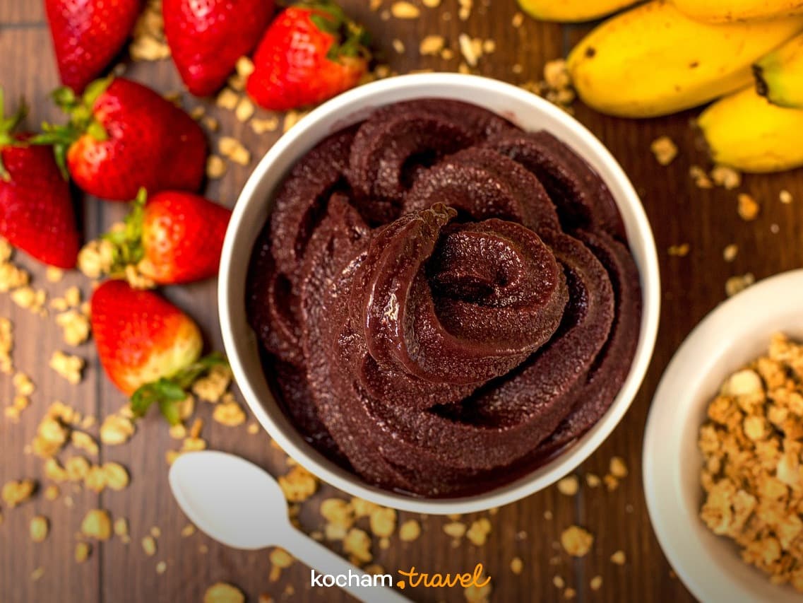Miska açaí ze świeżymi truskawkami, bananami i chrupiącą granolą.