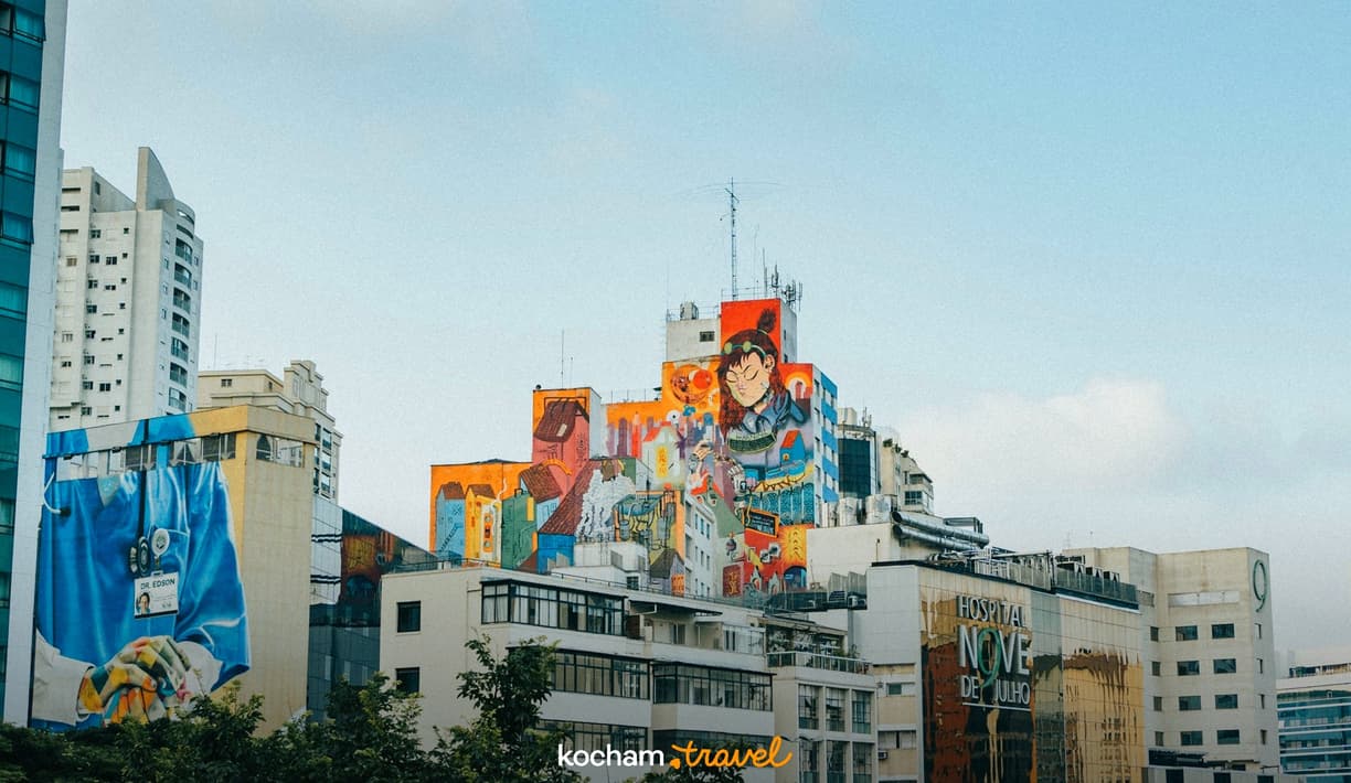 Kolorowe murale na budynkach w mieście, w tym lekarz i postać z anime.
