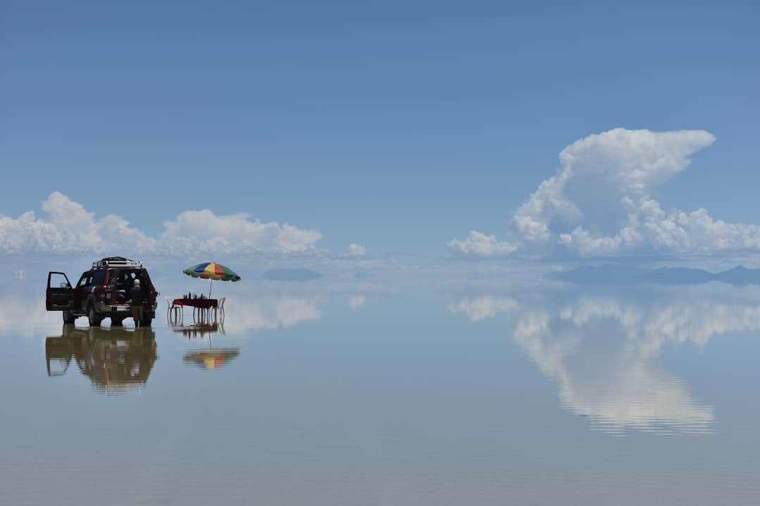Samochód terenowy i piknik na solnisku Salar de Uyuni, odbicie nieba.