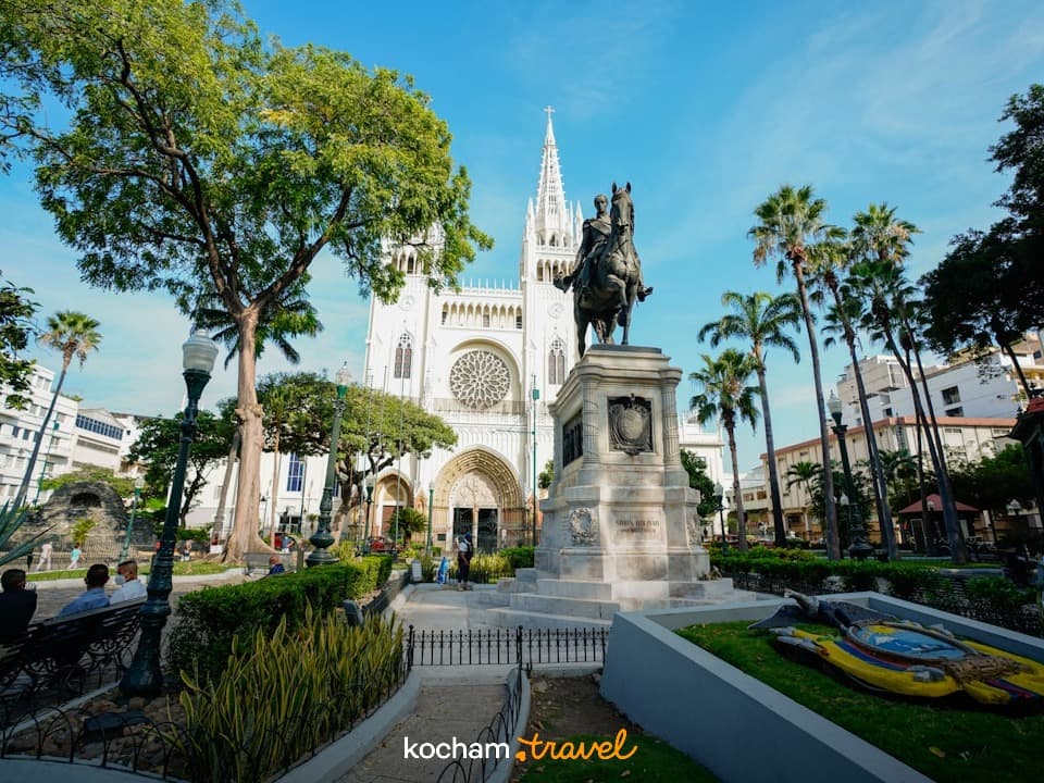 Biała katedra metropolitalna Guayaquil i pomnik Simóna Bolívara na słonecznym placu.