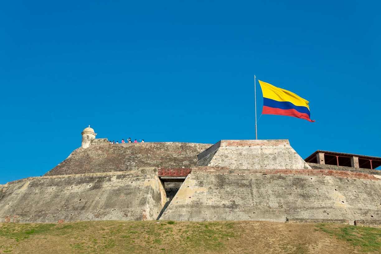 Flaga Kolumbii powiewa nad historyczną fortecą San Felipe w Cartagena.