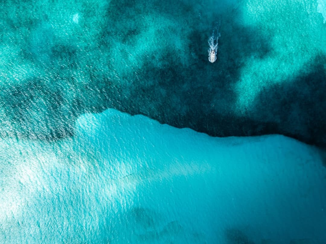 Turkusowy ocean z łodzią i różnymi głębokościami wody