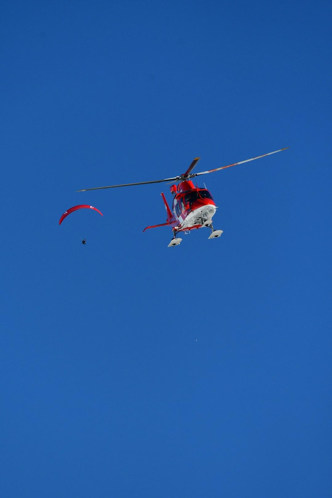 Helikopter i paralotniarz na niebie.