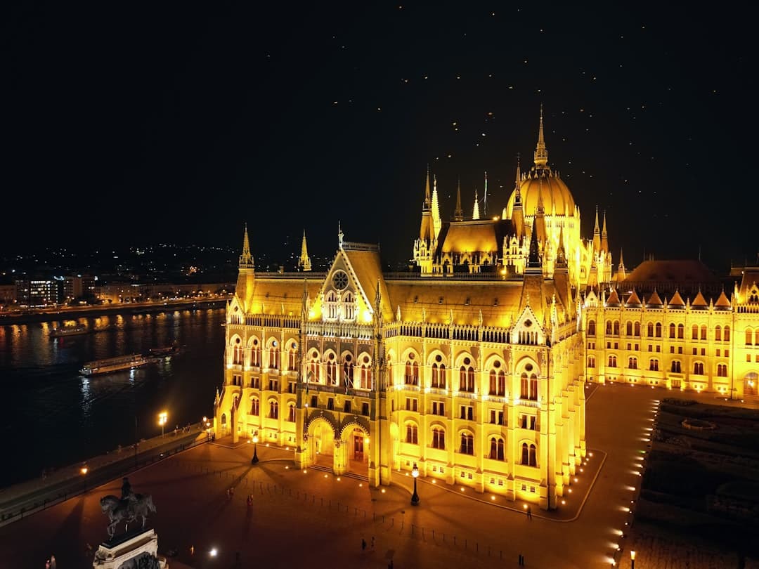 Węgierski Parlament nocą, oświetlony na żółto.