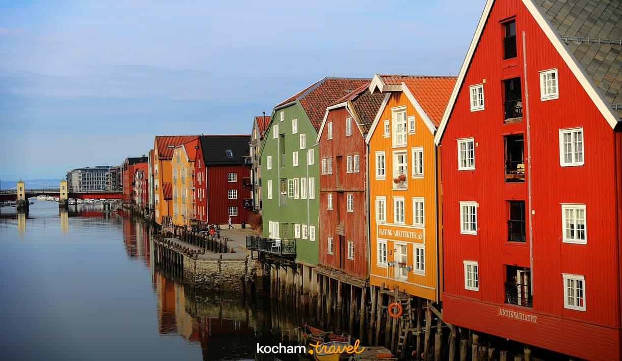 Kolorowe drewniane domy na palach nad rzeką Nidelva w Trondheim.