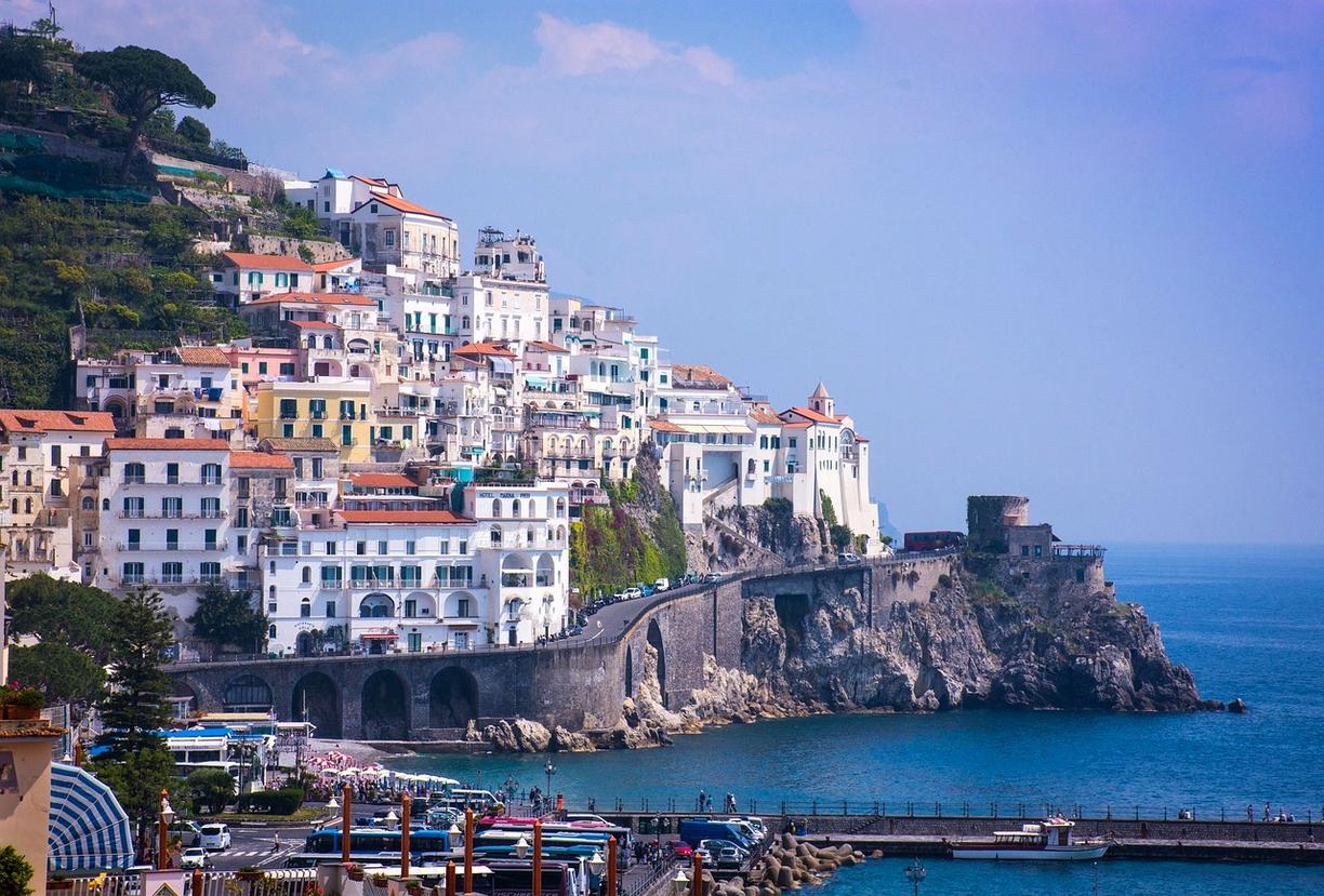 Słoneczne miasteczko Amalfi we Włoszech, budynki na klifach, turkusowe morze