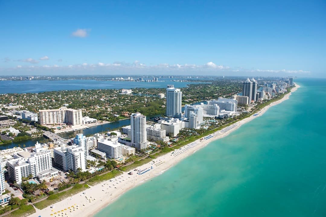 Miami Beach, Floryda: piaszczysta plaża, turkusowy ocean, wieżowce.
