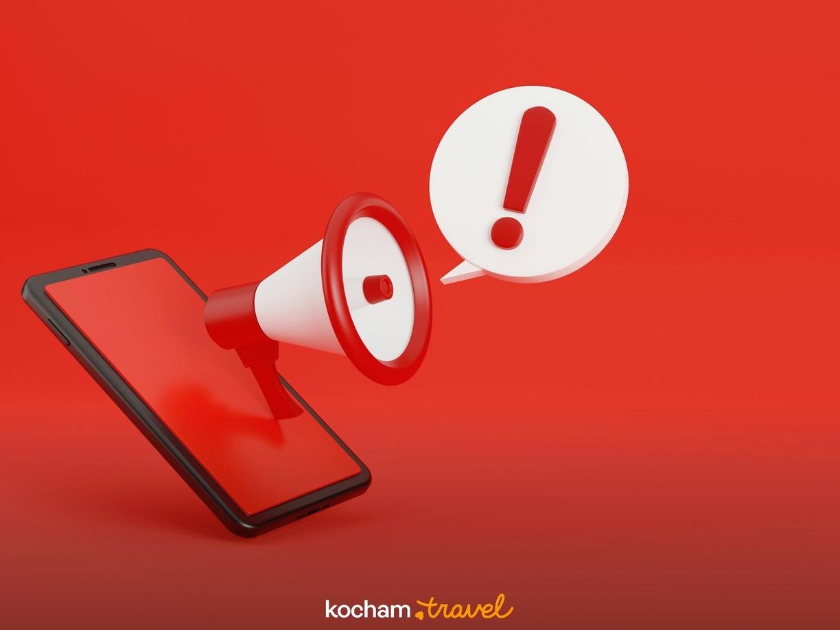 Megafon z wykrzyknikiem na ekranie smartfona, ważny komunikat.