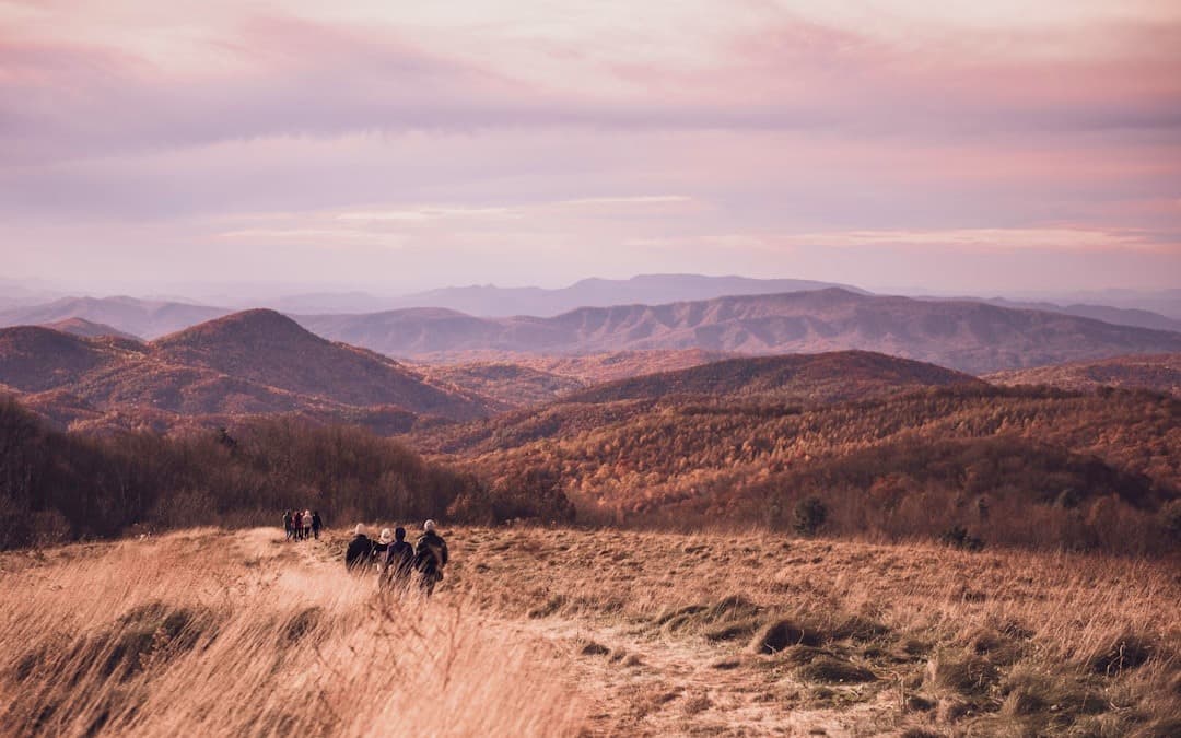 Panoramiczny widok górski, wędrowcy na szlaku o zmierzchu