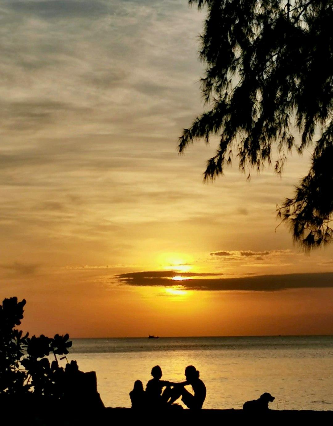 Rodzina ciesząca się zachodem słońca na plaży Beau Vallon
