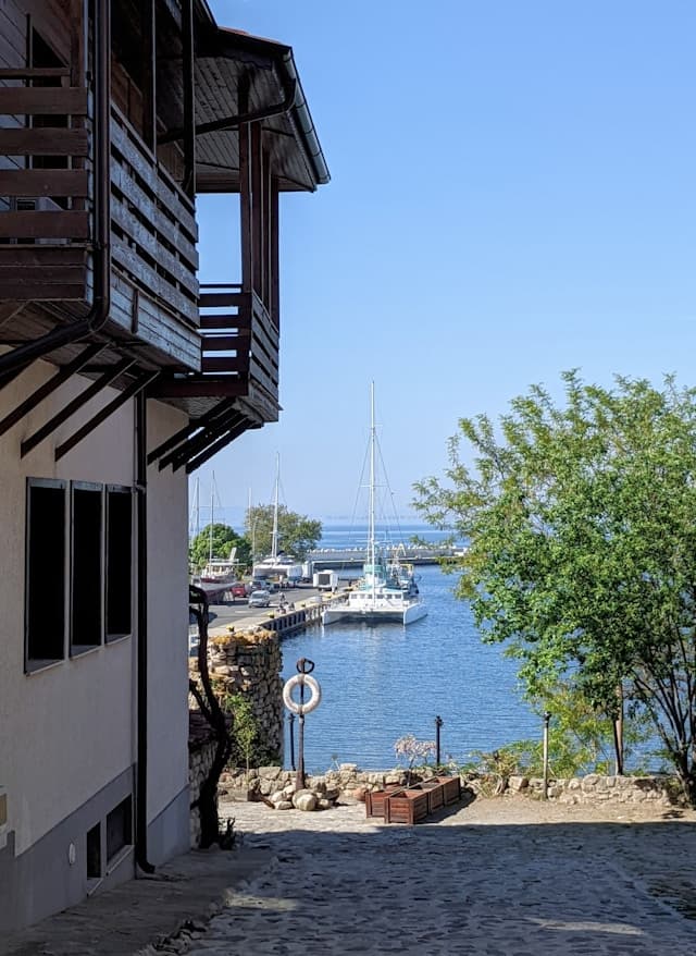 Stara nadmorska ulica z widokiem na port i zacumowane jachty.