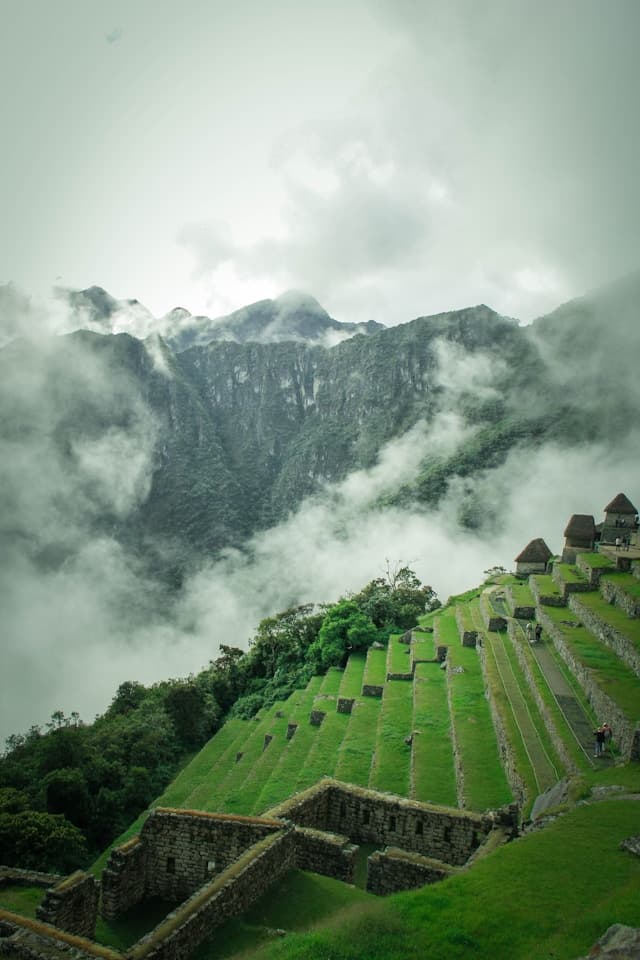 Machu Picchu, starożytne inkaskie tarasy i góry spowite chmurami.