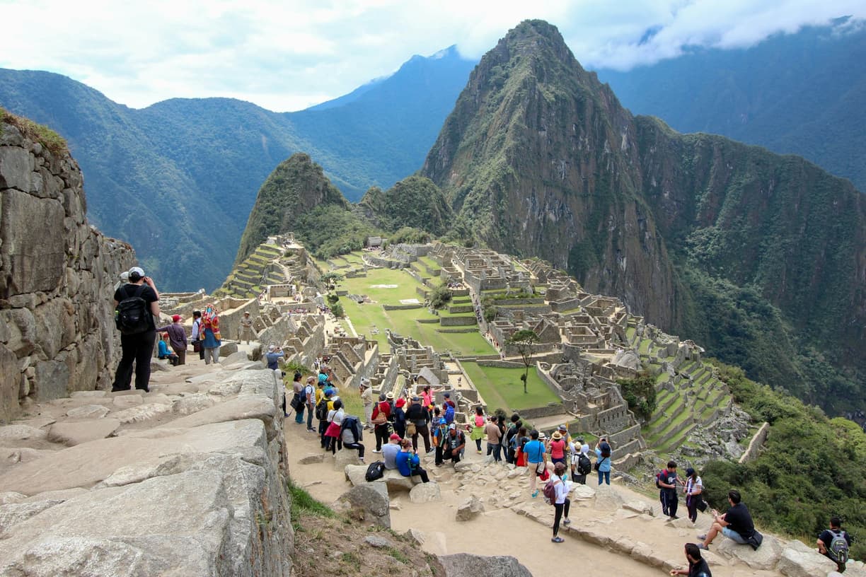 Turyści podziwiają starożytne miasto Machu Picchu i góry Andy w Peru.