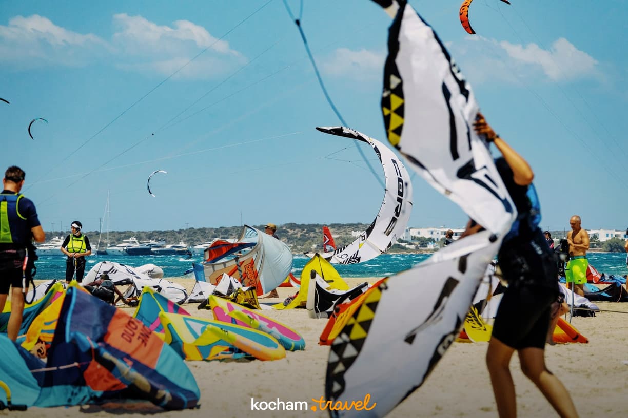 Kitesurfing na plaży: kolorowe latawce i błękitne morze.
