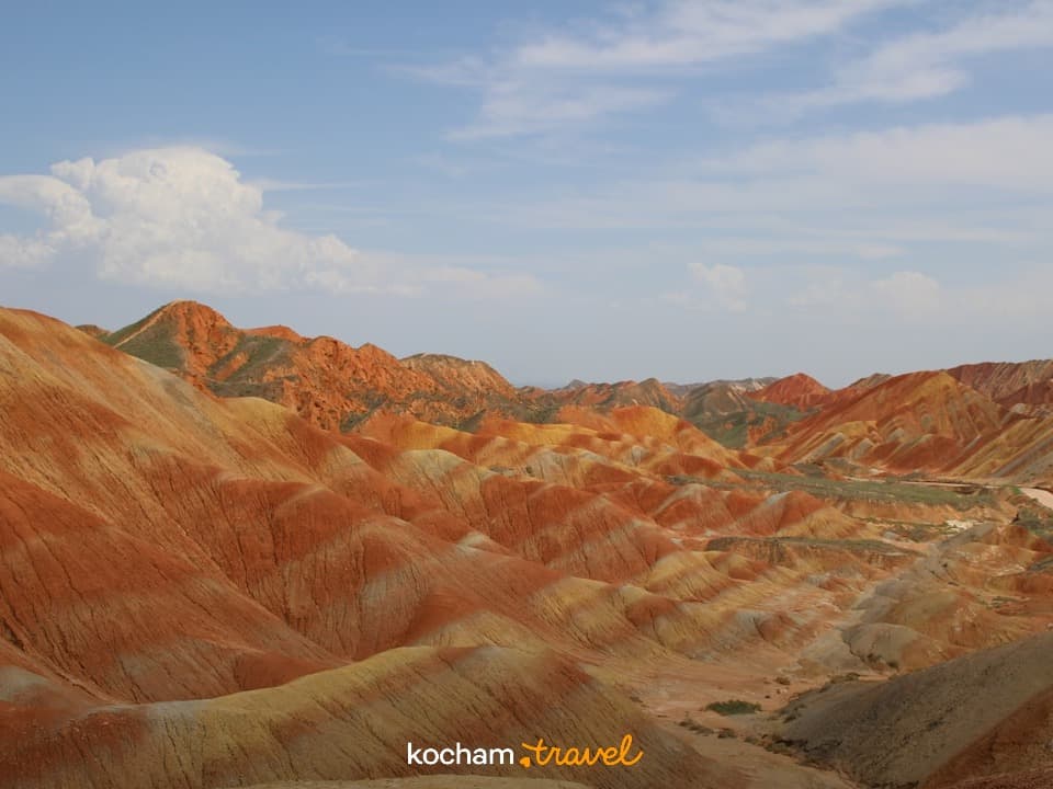 Wielobarwne warstwowe góry, pustynny krajobraz, geologiczne formacje skalne.