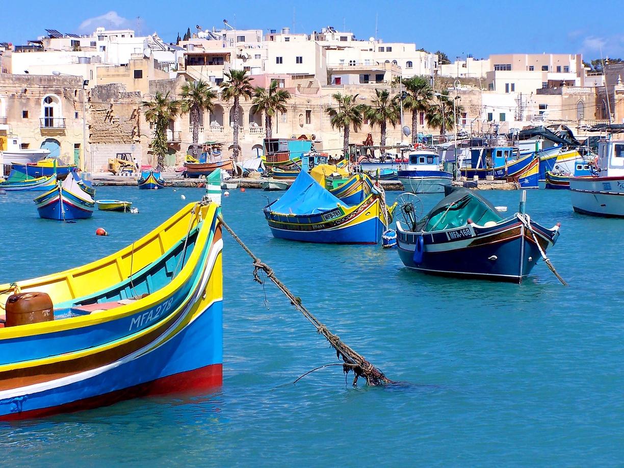 Kolorowe tradycyjne łodzie rybackie luzzu w porcie Marsaxlokk na Malcie.
