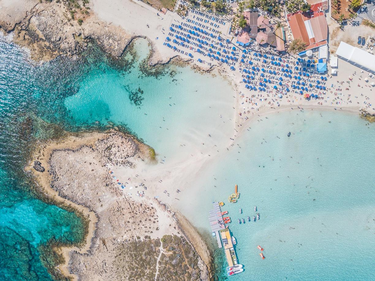 Plaża z turkusowym morzem i łodziami z lotu ptaka.