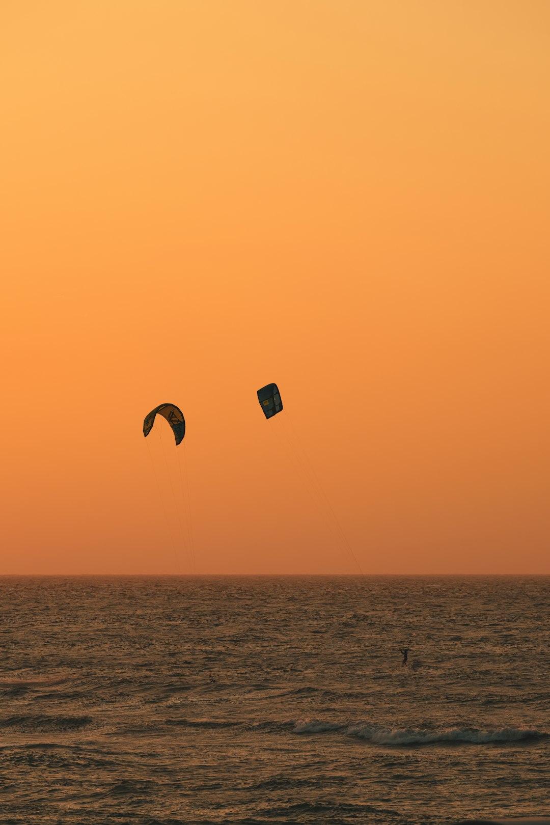 Kitesurferzy śmigający po falach o zachodzie słońca w Paje