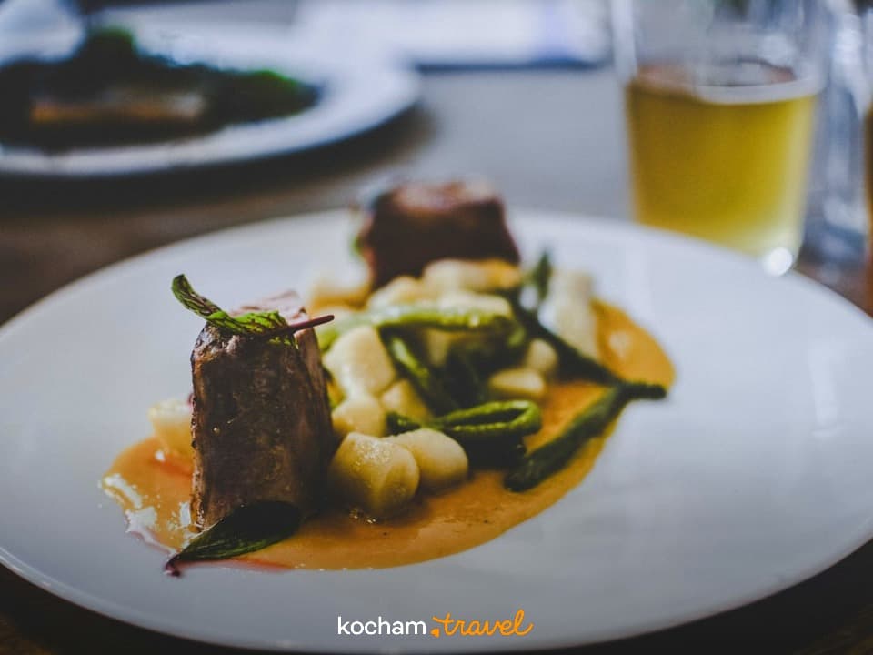 Wykwintne danie mięsne z gnocchi i zielonymi warzywami w restauracji.