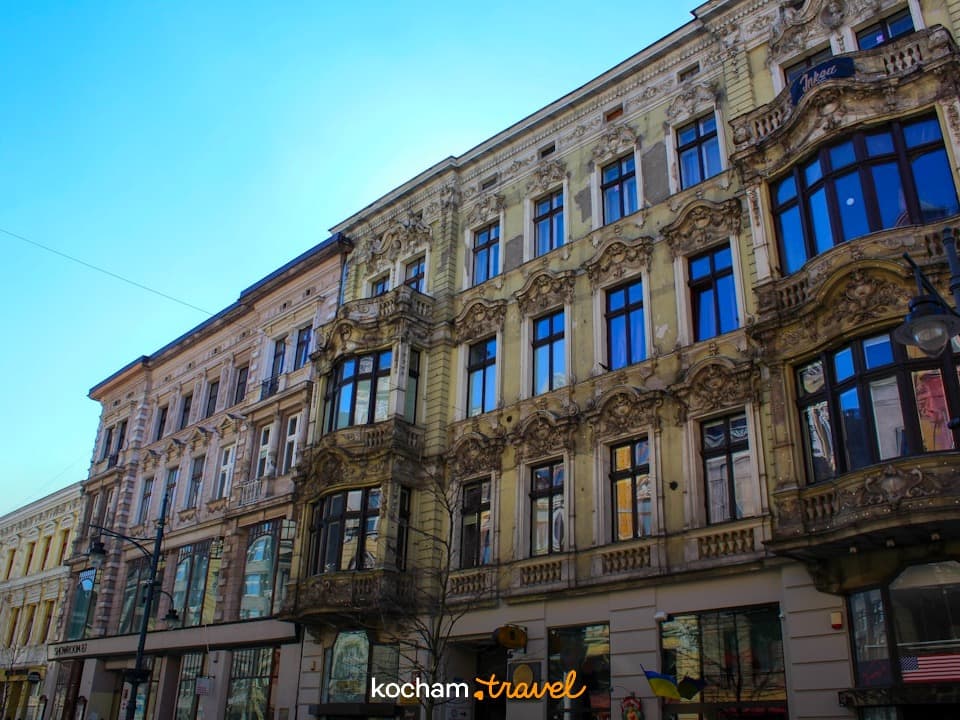 Ozdobne, zabytkowe kamienice miejskie z wykuszami pod błękitnym niebem.