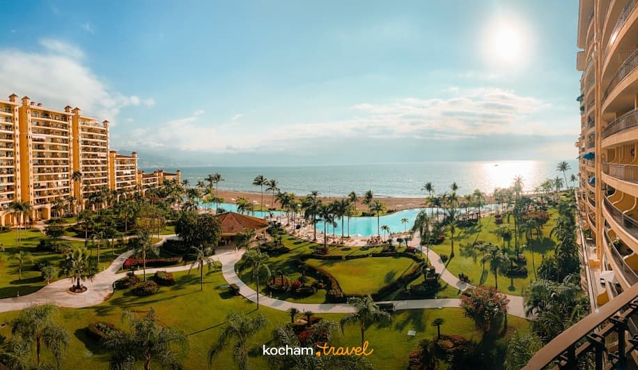 Panoramiczny luksusowy resort, zielone ogrody, basen, plaża, ocean.