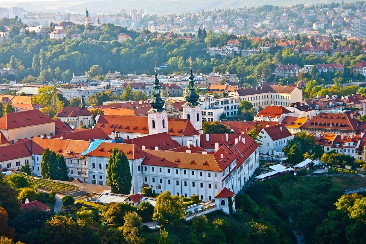 Widok na zabytkowe miasto, klasztor, zielone kopuły, czerwone dachy.