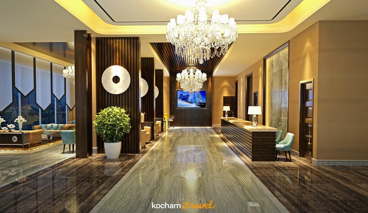 Elegancki hol hotelowy z lśniącym marmurem i kryształowymi żyrandolami.