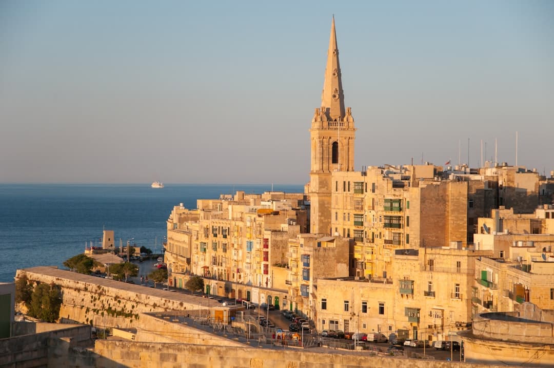 Valletta Malta: katedra, historyczne budynki, błękitne morze, zachód słońca.