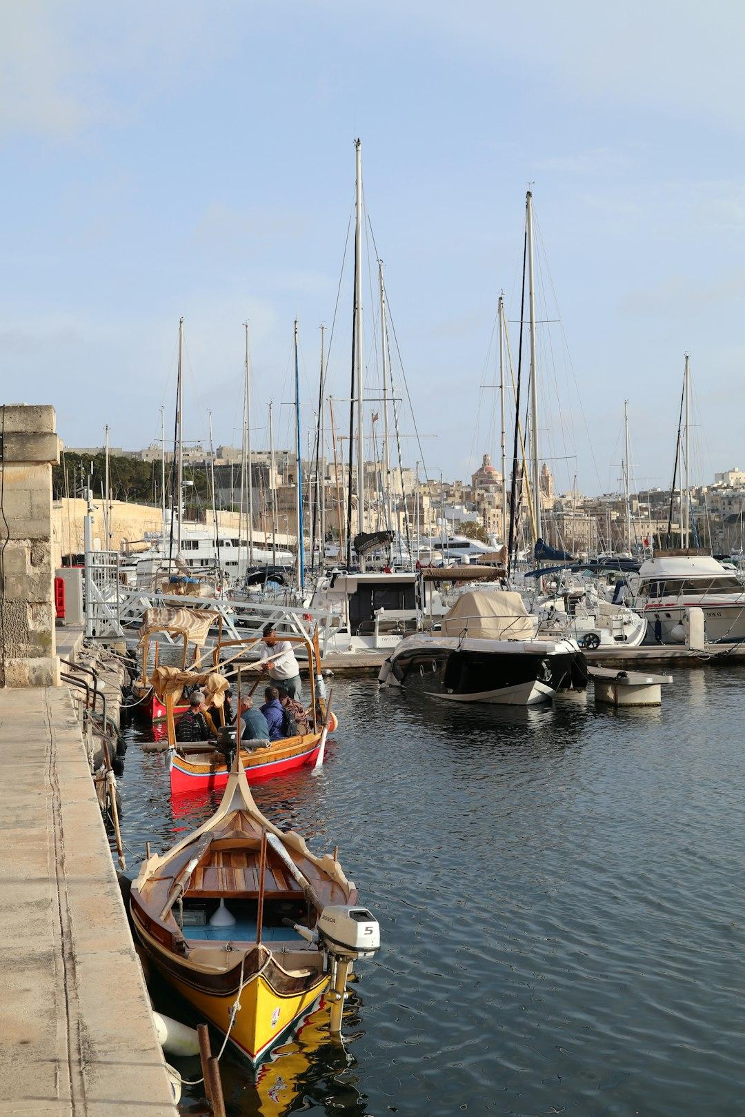 Maltański port z tradycyjnymi łodziami luzzu i nowoczesnymi jachtami.