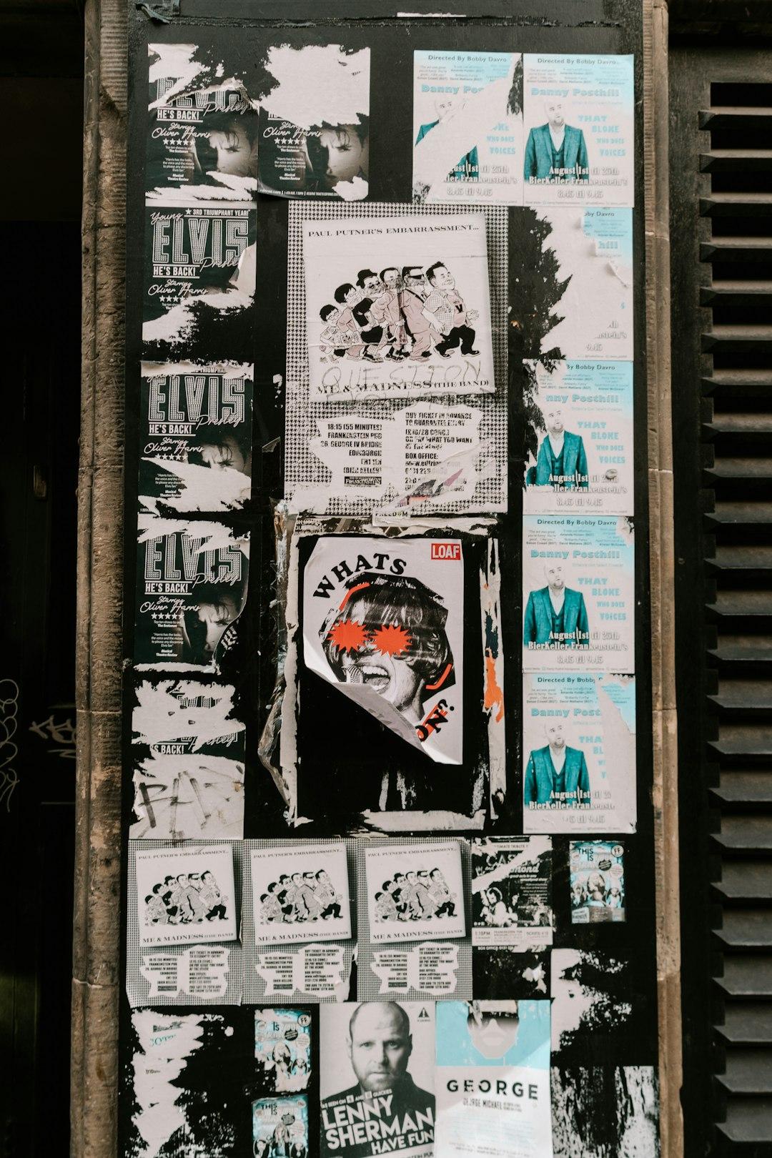 Ściana pokryta wieloma podartymi plakatami koncertowymi i reklamami wydarzeń.