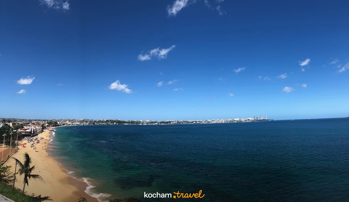 Złota plaża, turkusowy ocean i rozległa panorama miasta.