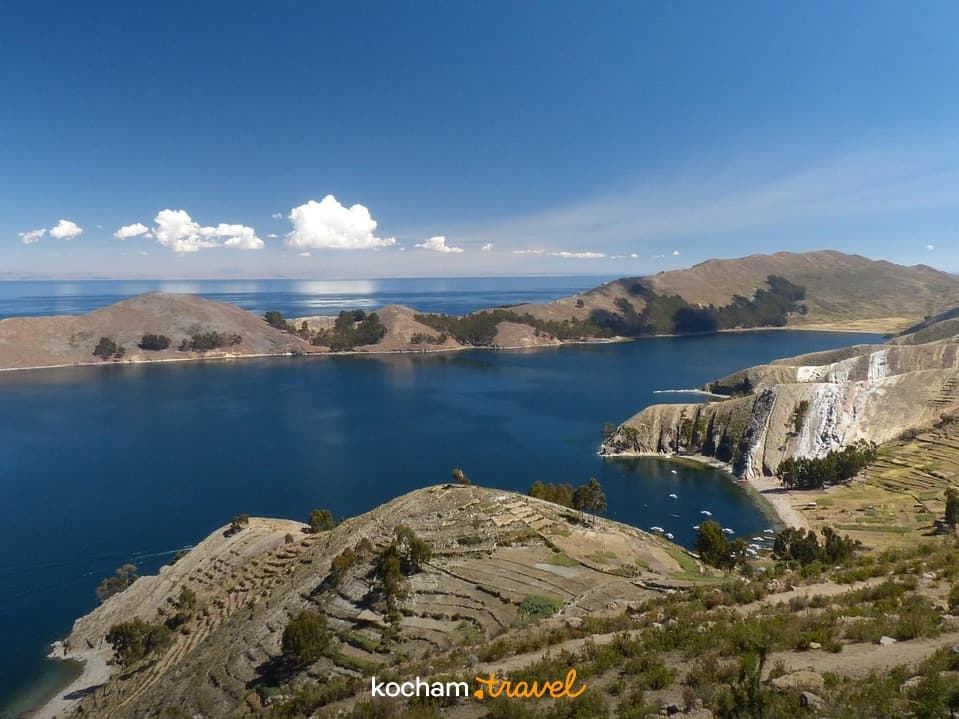Panoramiczny widok: Jezioro Titicaca, góry, tarasowe pola.