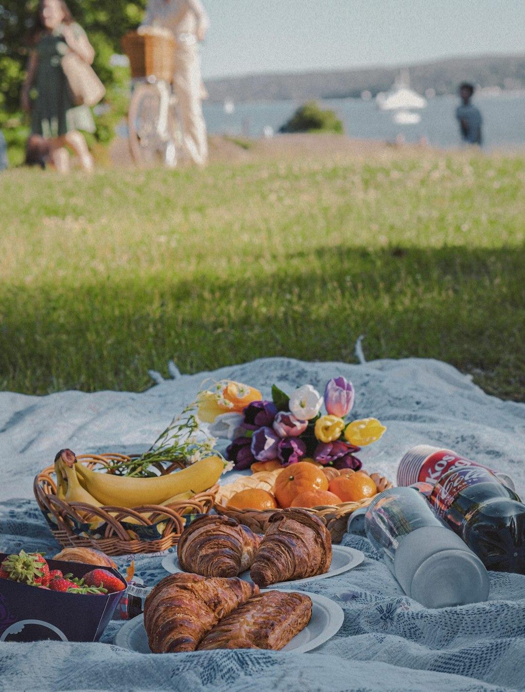 Piknik z jedzeniem i napojami na trawie.