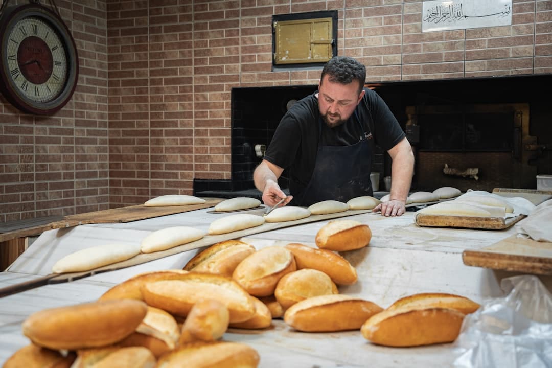 Tradycyjny piekarz przygotowuje świeże bochenki chleba do pieczenia.