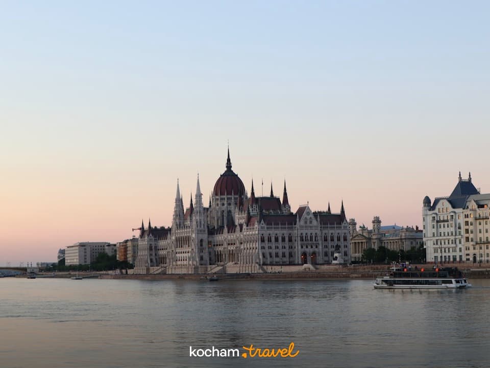 Budapeszt, Parlament Węgierski nad Dunajem o zachodzie słońca, łódź wycieczkowa.