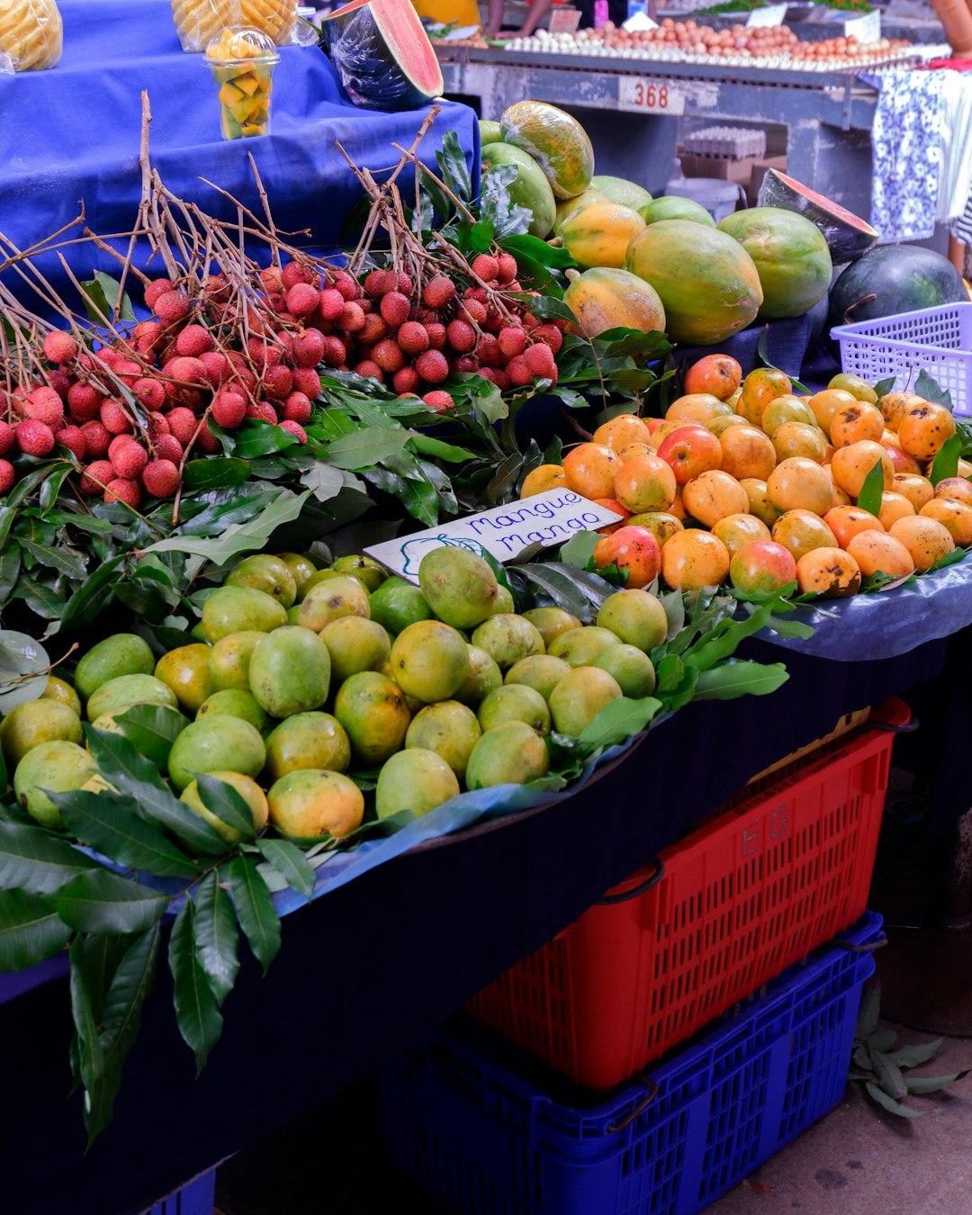 Świeże owoce tropikalne: mango, liczi, papaje na stoisku targowym.