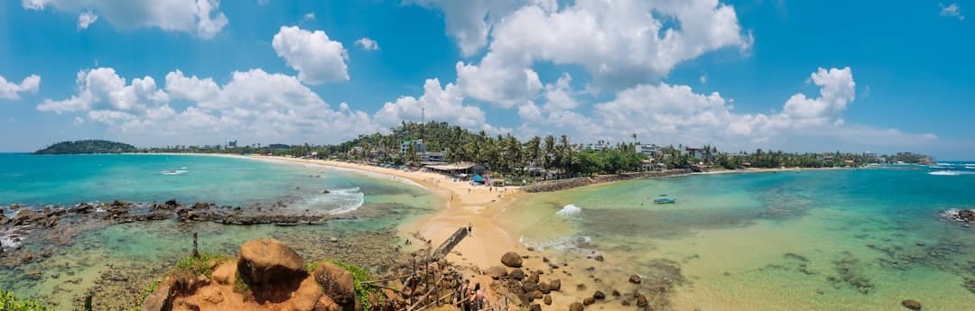 Panoramiczny widok tropikalnej plaży, turkusowej wody, palm, słonecznego wybrzeża.