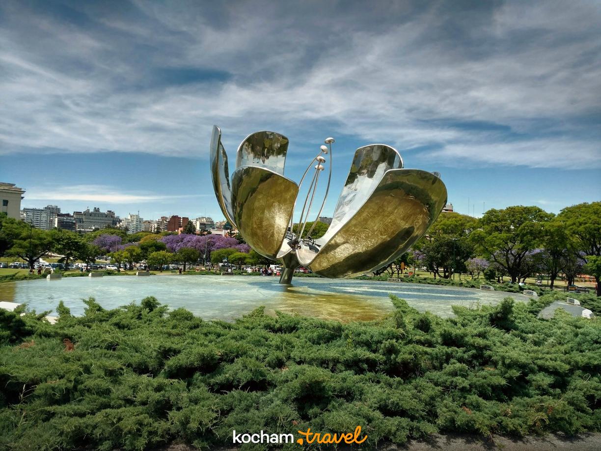 Słynna rzeźba Floralis Genérica w Buenos Aires, z jakarandami i stawem.