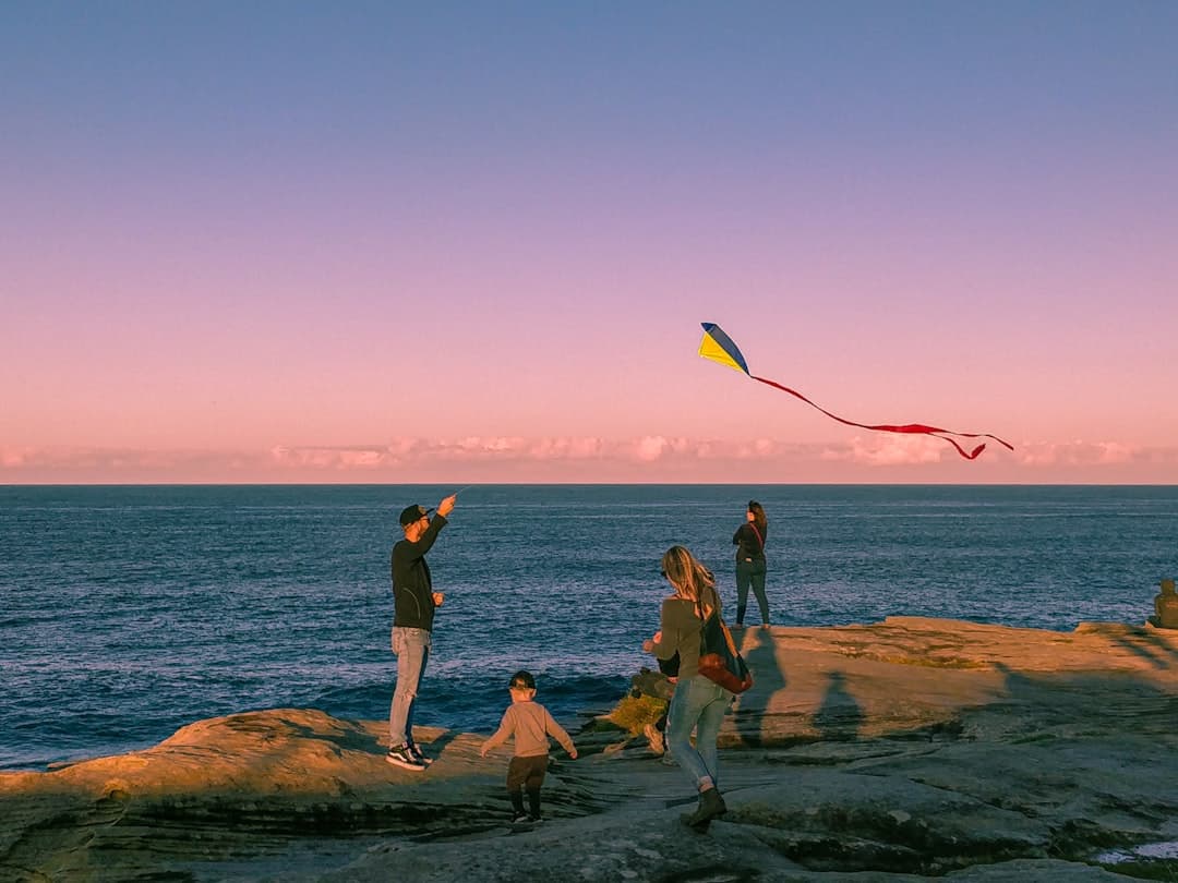Rodzina uprawiająca kitesurfing podczas zachodu słońca