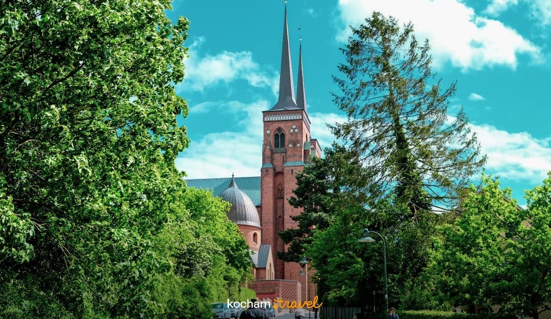 Katedra w Roskilde, Dania, gotycka architektura, uliczka, zieleń, ludzie.