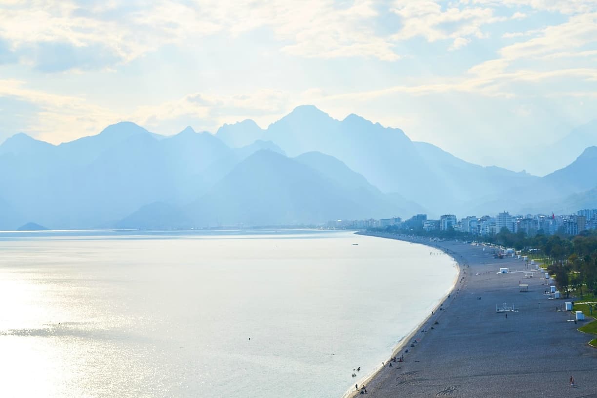 Panoramiczny widok na plażę, miasto i góry, lśniąca woda