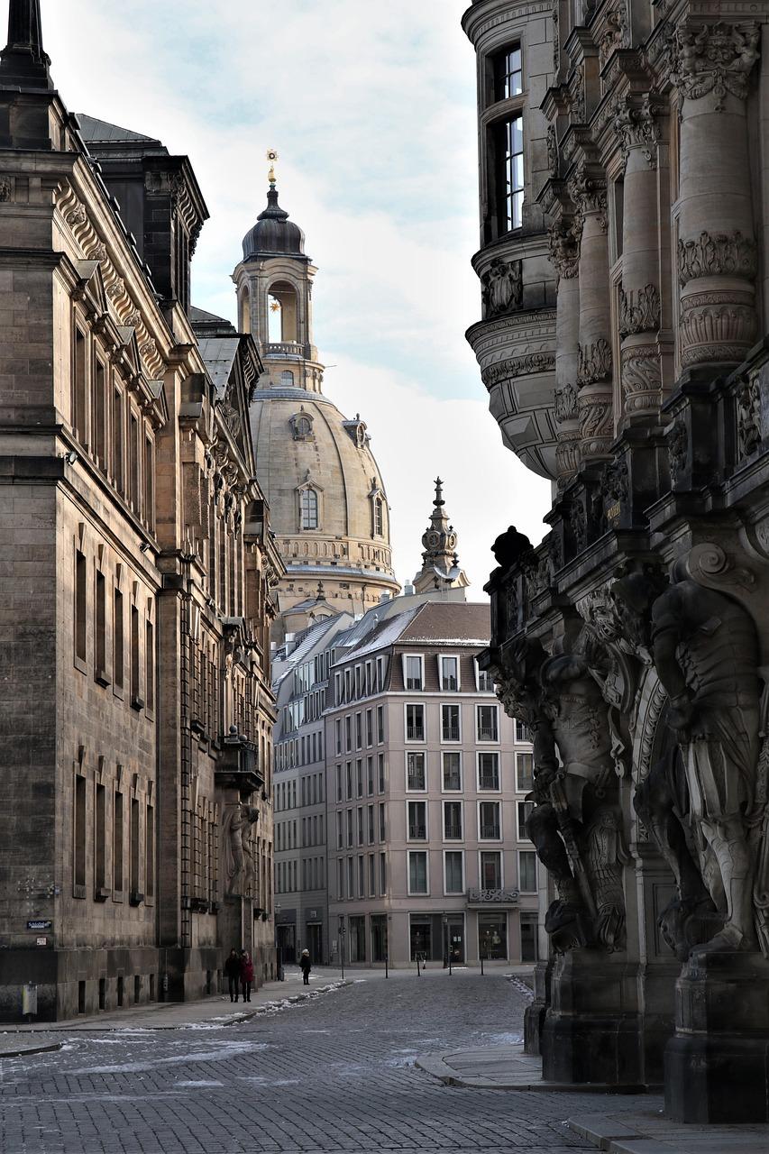 Drezno: brukowana ulica, Frauenkirche, zabytkowe kamienice, zimowy krajobraz.