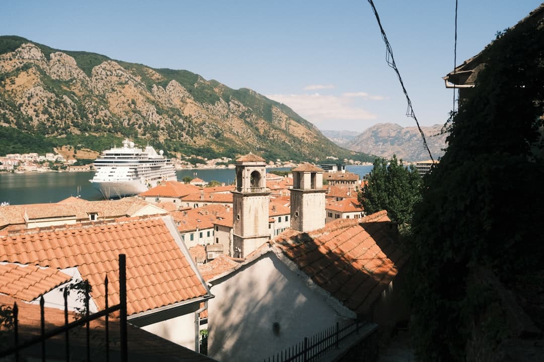 Kotor, Czarnogóra: zatoka, góry, statek wycieczkowy, czerwone dachy starego miasta.