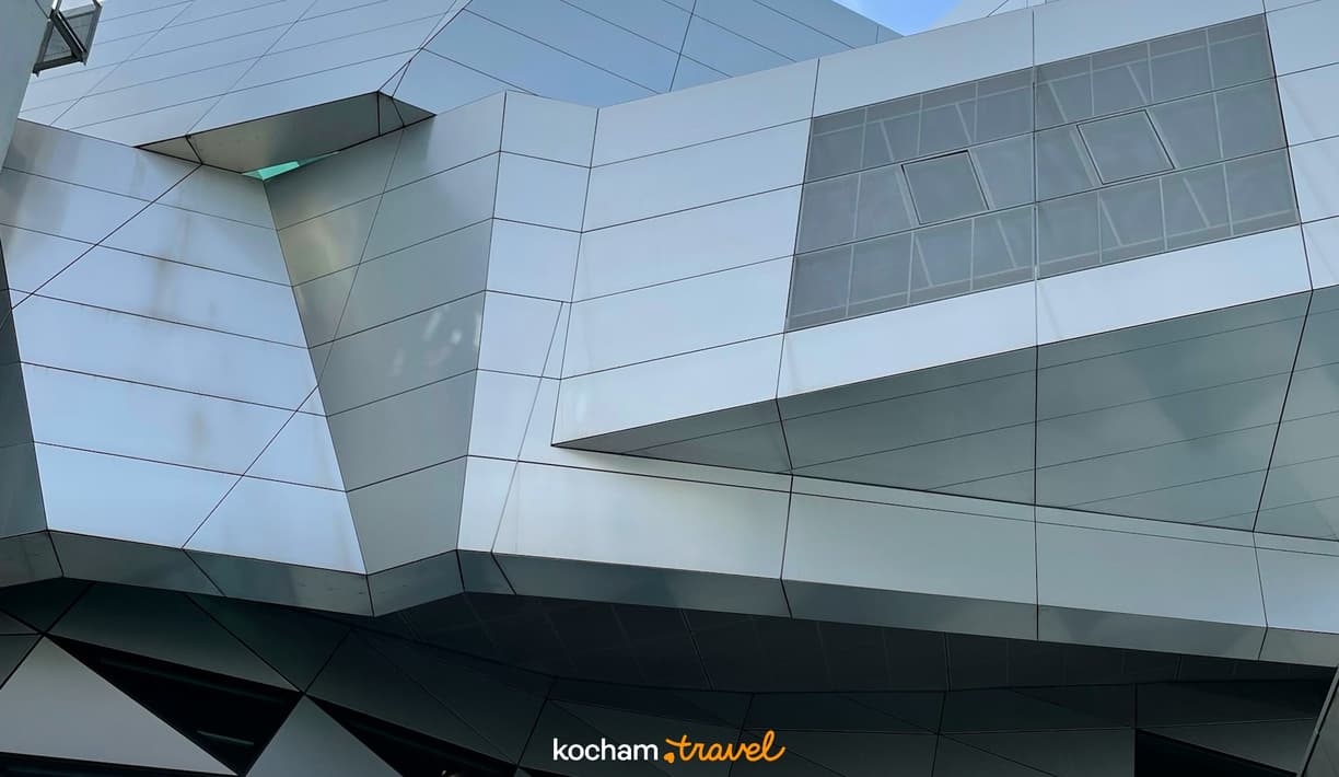 Geometryczna fasada nowoczesnego budynku z metalowymi panelami.