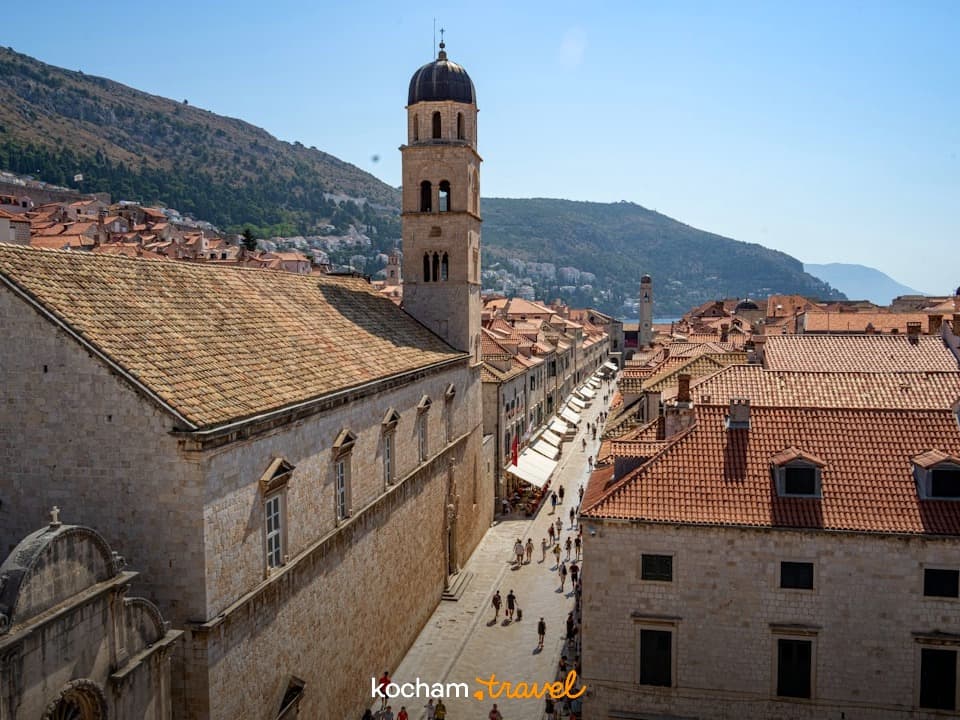 Historyczna ulica Stradun w Dubrowniku, dzwonnica, czerwone dachy, turyści.