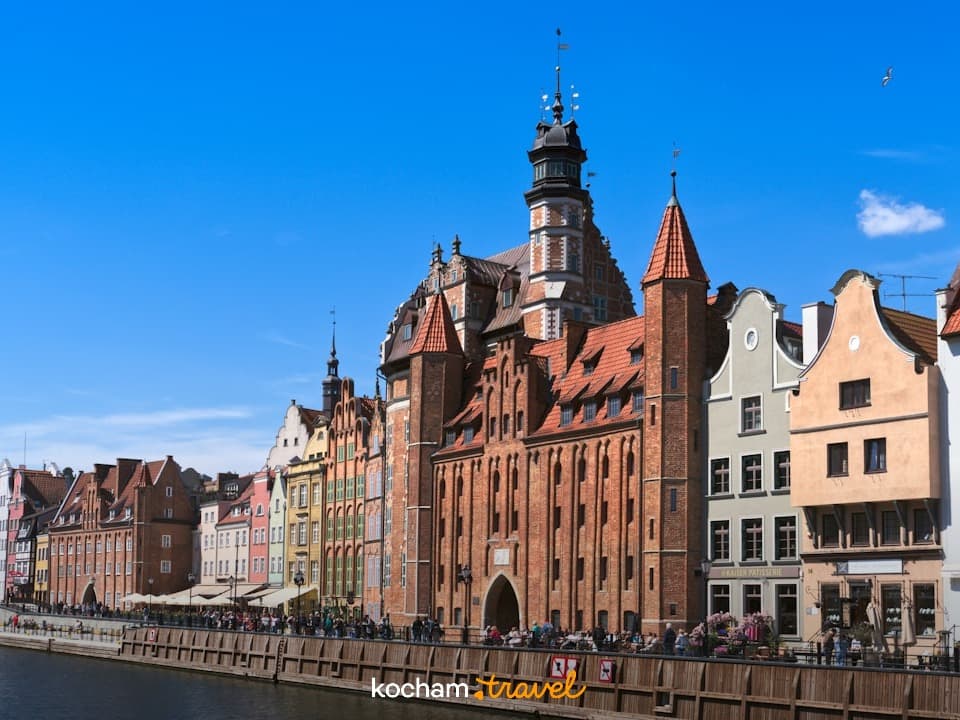 Gdańsk, Polska: Kolorowe kamienice i Brama Zielona nad rzeką Motławą.