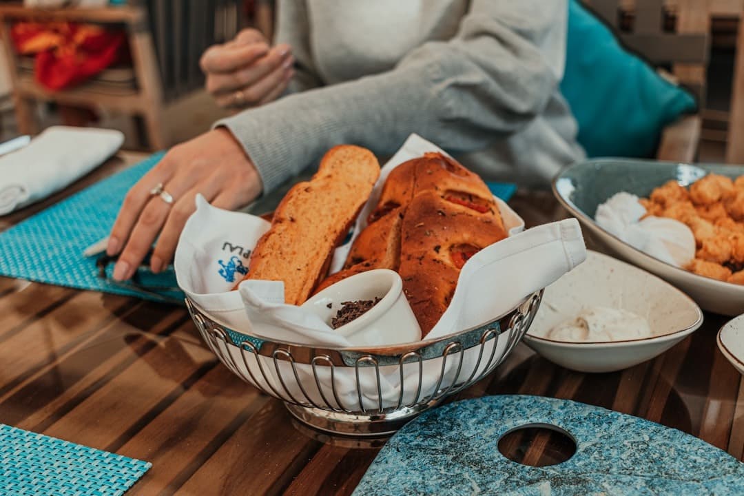 Koszyk focaccii i bagietek, przystawki na drewnianym stole w restauracji.